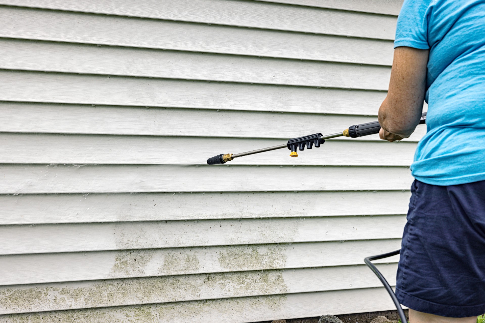 Senior Woman DIY Power Washing Home Siding