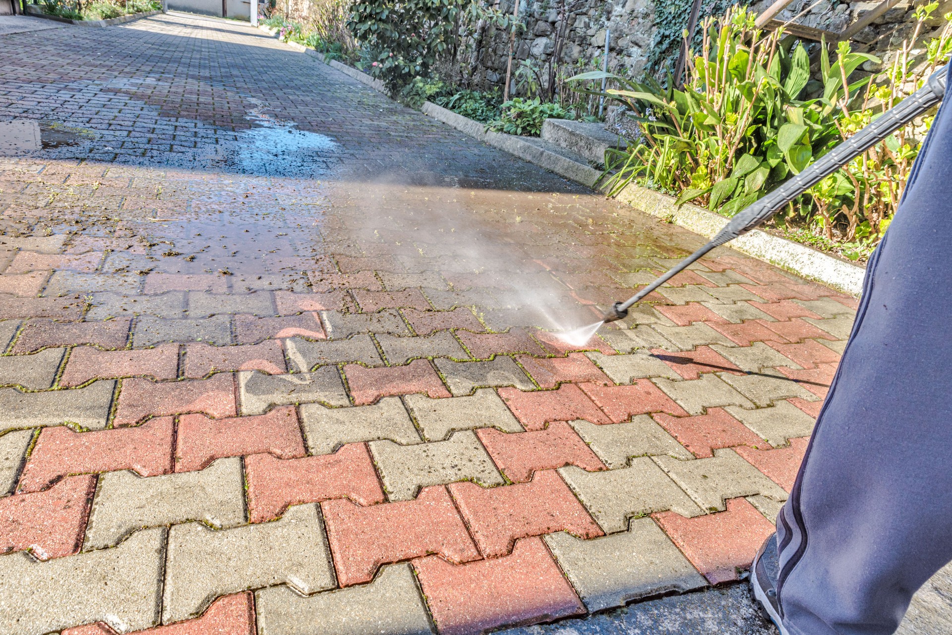 Senior Man Cleaning the Back Yard with High Pressure Washer